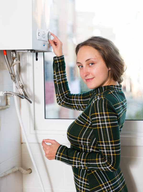 Woman adjusting water heater temperature