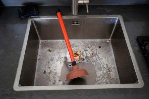 Overflowing kitchen sink, clogged drain, plunger